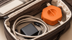 Enroulo orange et câble rangés dans un sac de voyage